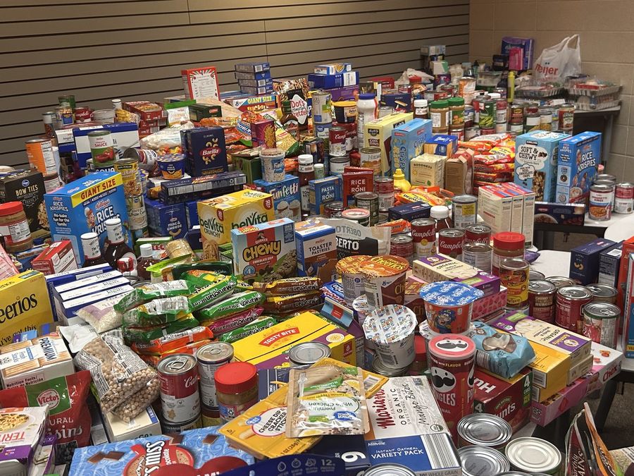 Tables covered end to end with donated cereal, pasta, canned goods and snacks after drive week